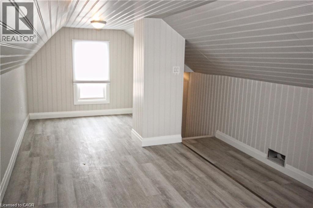 This room features sloped, paneled ceilings, paneled walls, and a window providing natural illumination - 1356 Upper Wellington Street, Hamilton, ON - Indoor Photo Showing Other Room