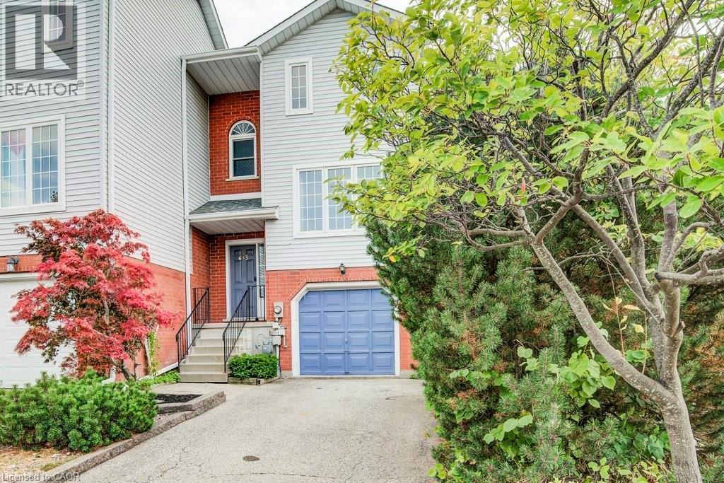 View of front facade with brick siding, an attached garage, and driveway - 633 Grange Crescent, Waterloo, ON - Outdoor