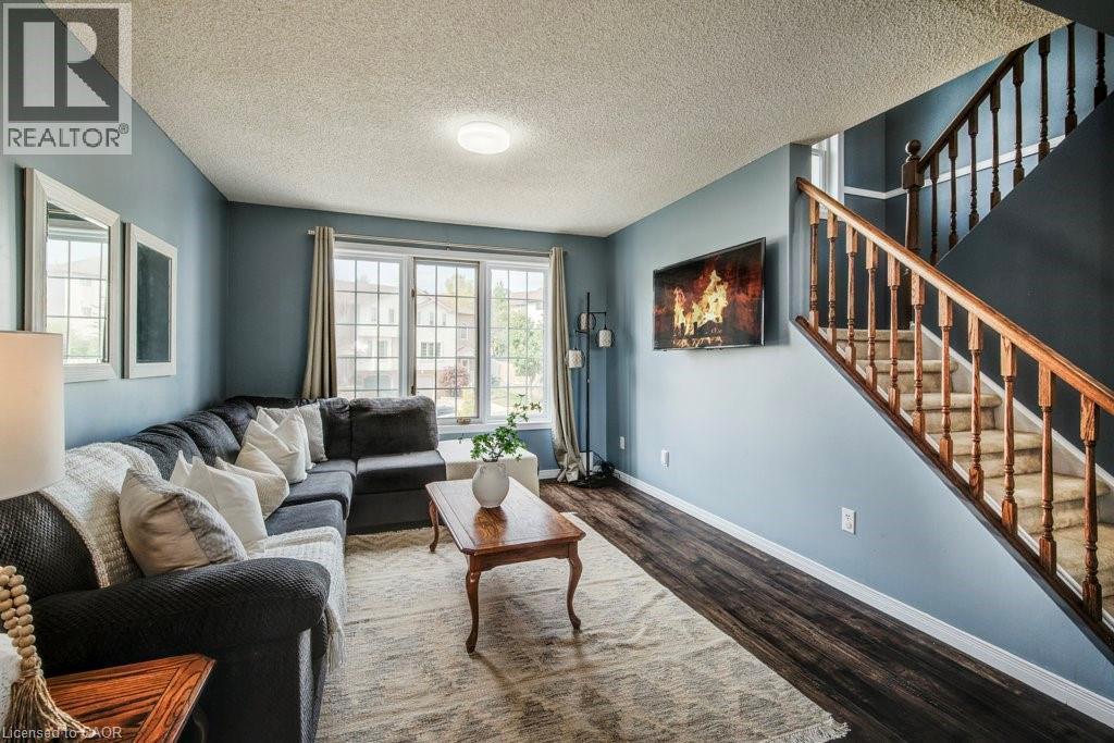 Living area featuring a textured ceiling and dark wood-style floors - 633 Grange Crescent, Waterloo, ON - Indoor Photo Showing Living Room