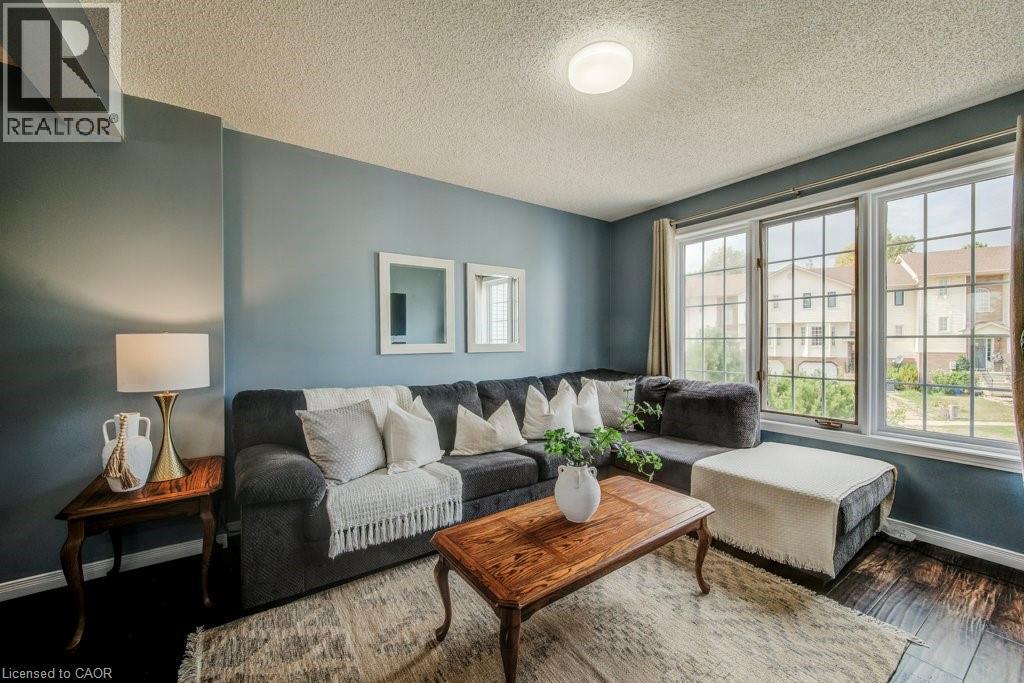 Living area featuring wood finished floors and a textured ceiling - 633 Grange Crescent, Waterloo, ON - Indoor Photo Showing Living Room