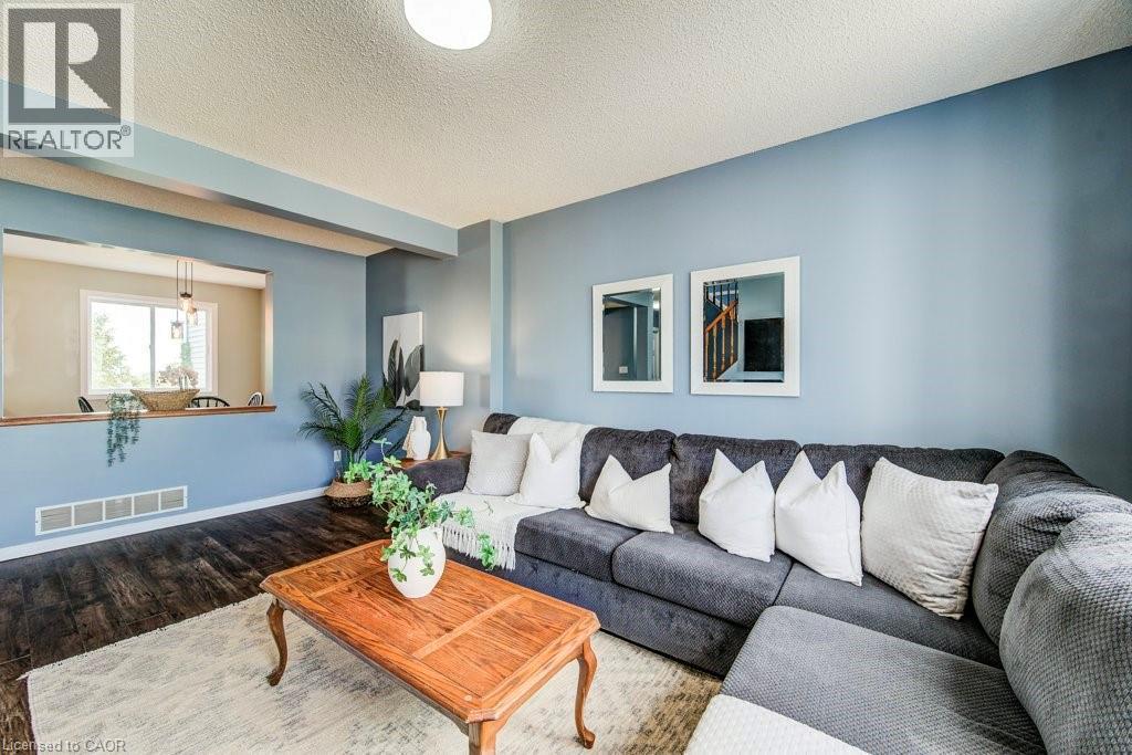 Living room with wood finished floors and a textured ceiling - 633 Grange Crescent, Waterloo, ON - Indoor Photo Showing Living Room
