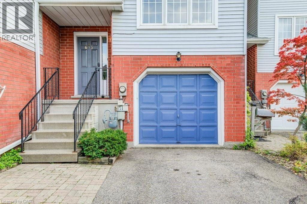 Entrance to property with a garage, brick siding, and driveway - 633 Grange Crescent, Waterloo, ON - Outdoor With Exterior