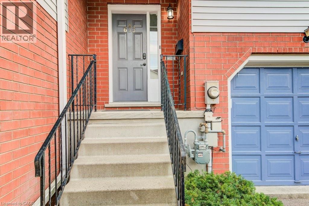 View of exterior entry featuring brick siding and an attached garage - 633 Grange Crescent, Waterloo, ON - Outdoor With Exterior