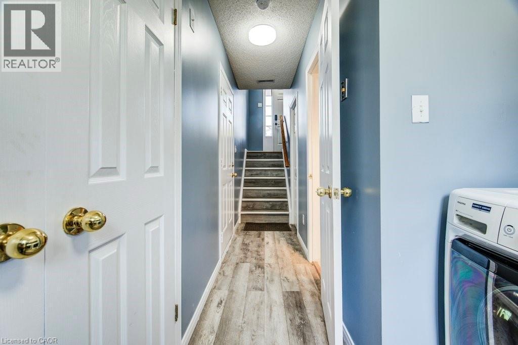 Hall with washer / clothes dryer, a textured ceiling, and light wood finished floors - 633 Grange Crescent, Waterloo, ON - Indoor