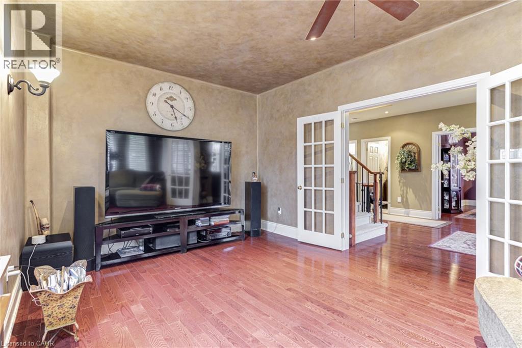 Living area featuring hardwood floors, a ceiling fan, and double french doors - 4278 Clubview Drive, Burlington, ON - Indoor Photo Showing Other Room