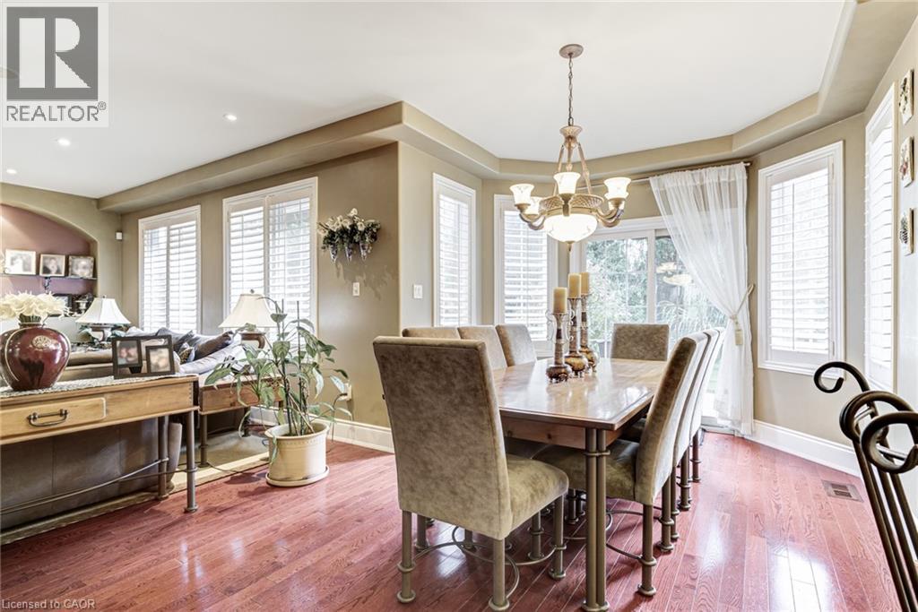 Dining area with hardwood floors, a bay window with plantation shutters, and a chandelier - 4278 Clubview Drive, Burlington, ON - Indoor Photo Showing Dining Room