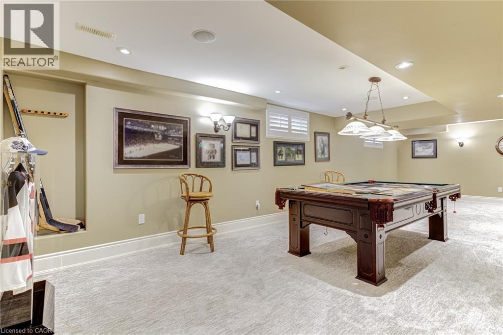 This spacious room features light-colored carpeting, recessed lighting, and a pool table with an overhead light fixture - 4278 Clubview Drive, Burlington, ON - Indoor Photo Showing Other Room