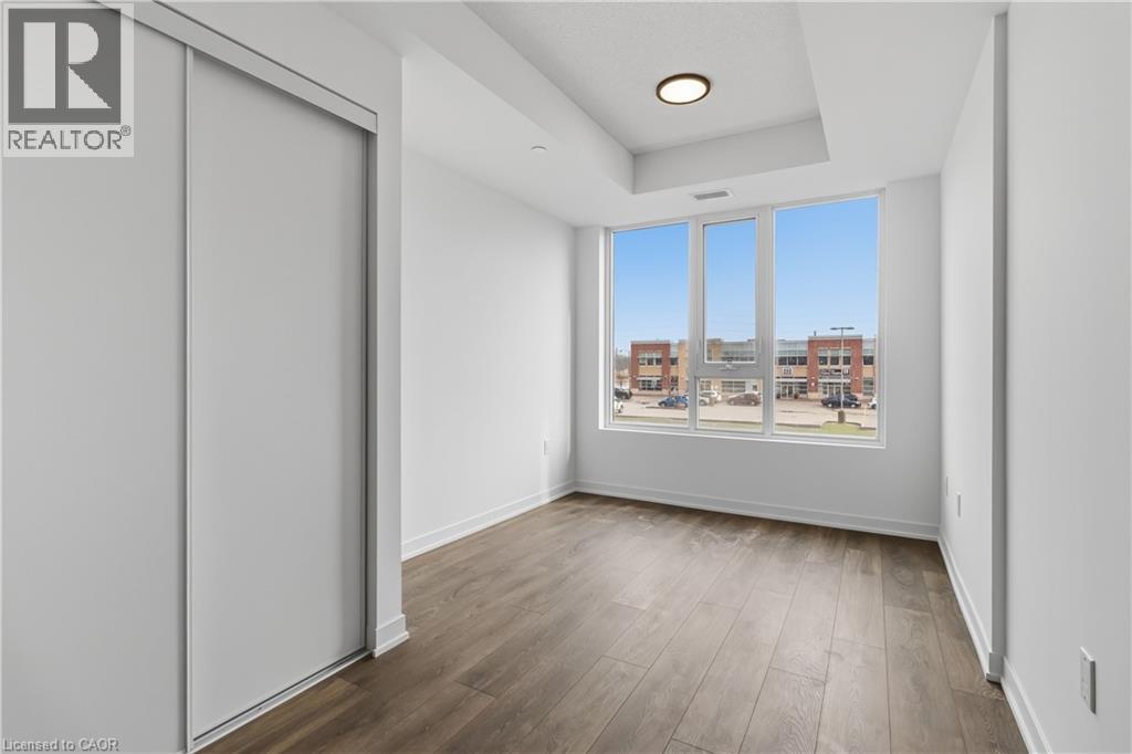 This room features large windows providing ample natural light and views of the surrounding buildings - 4878 Powers Common Unit# 224, Burlington, ON - Indoor Photo Showing Other Room