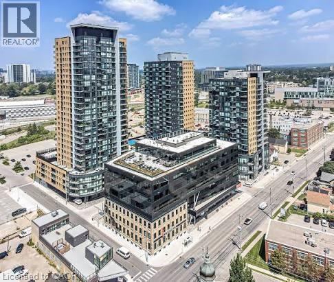 This aerial view showcases a collection of modern high-rise buildings featuring extensive glass facades and balconies - 108 Garment Street S Unit# 708, Kitchener, ON - Outdoor