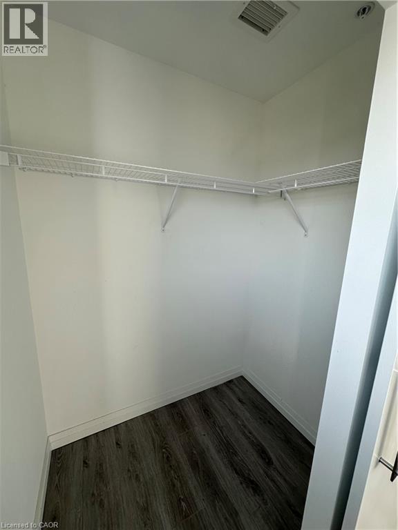 This closet features neutral white walls, wire shelving, and wood-look flooring - 108 Garment Street S Unit# 708, Kitchener, ON - Indoor With Storage