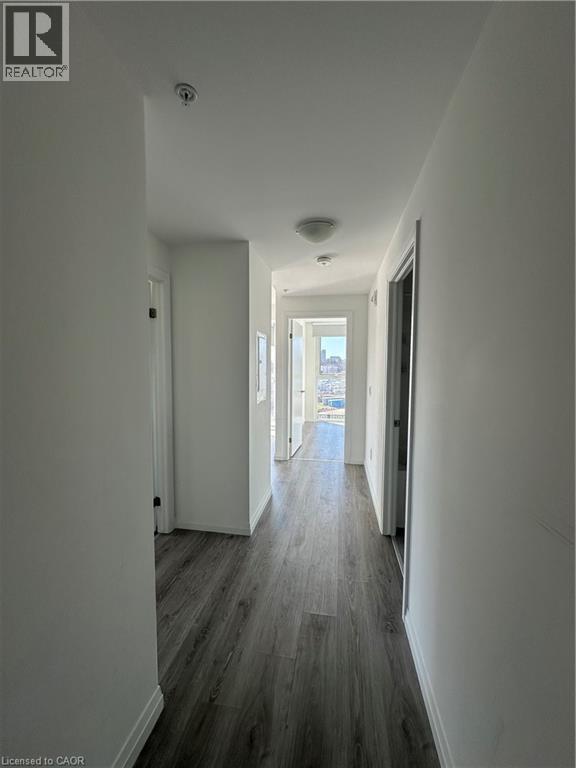 Hallway featuring modern grey wood-style flooring, white walls, and flush-mount ceiling lights - 108 Garment Street S Unit# 708, Kitchener, ON - Indoor Photo Showing Other Room