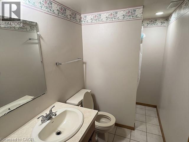 Bathroom featuring a vanity with an integrated sink, a wall-mounted mirror, white ceramic tile flooring, and a recessed ceiling light - 70 Bechtel Drive, Kitchener, ON - Indoor Photo Showing Bathroom