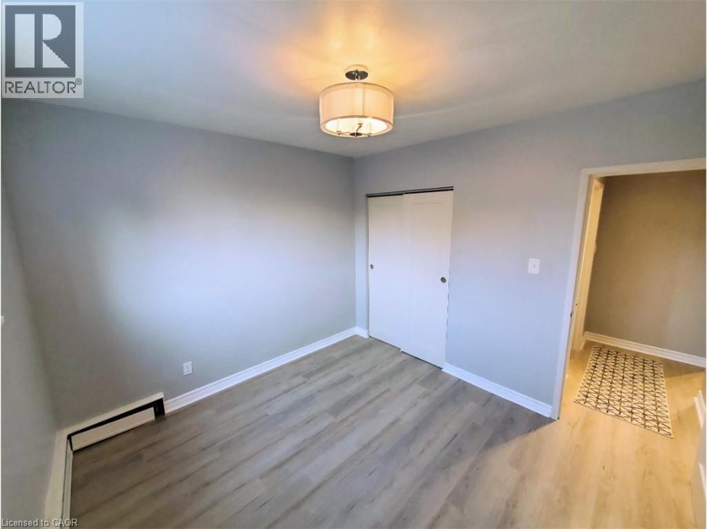 This room features light-colored walls, light-toned flooring, and a ceiling-mounted light fixture - 981 Mohawk Road E, Hamilton, ON - Indoor Photo Showing Other Room