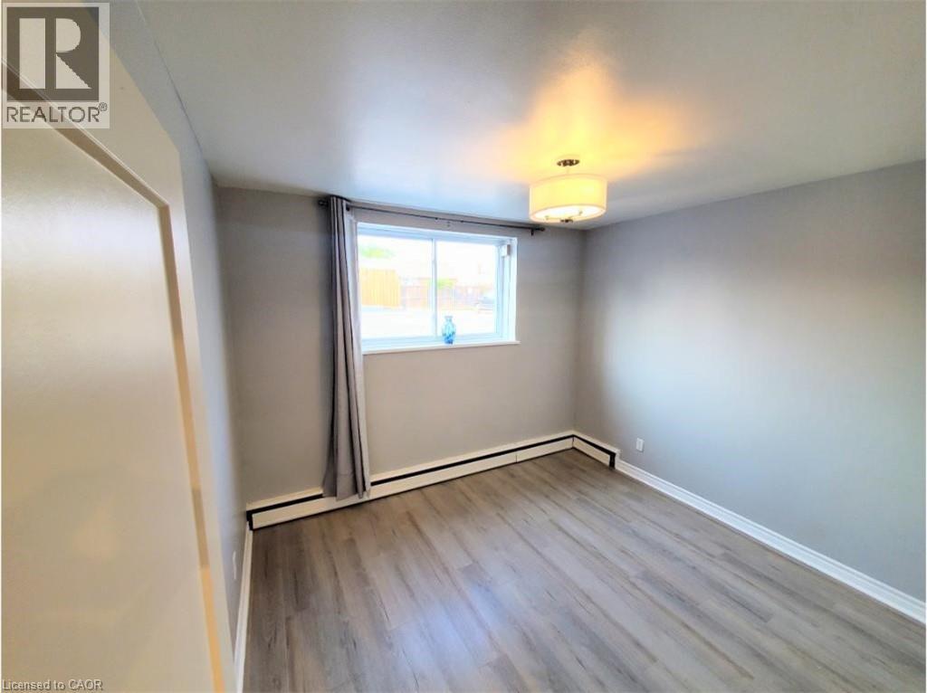 The interior room features light grey walls and a window providing natural light - 981 Mohawk Road E, Hamilton, ON - Indoor Photo Showing Other Room
