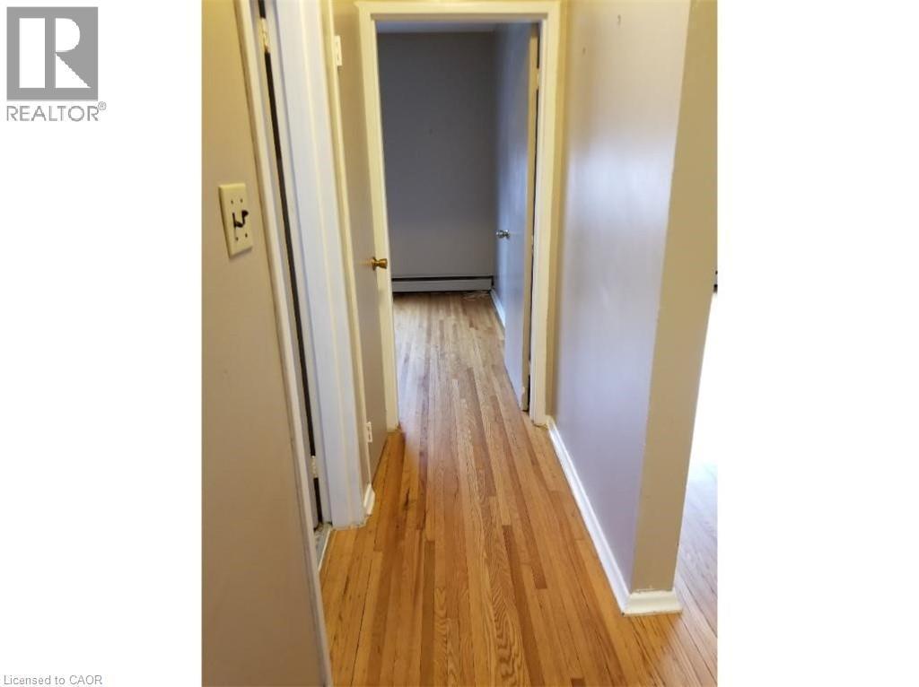 Hallway featuring hardwood flooring, light-colored walls, and white trim - 981 Mohawk Road E, Hamilton, ON - Indoor Photo Showing Other Room