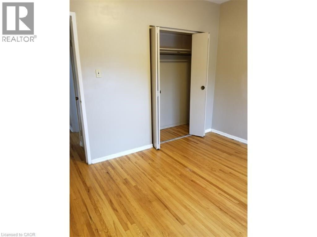 This room features hardwood floors and a closet with bi-fold doors - 981 Mohawk Road E, Hamilton, ON - Indoor Photo Showing Other Room