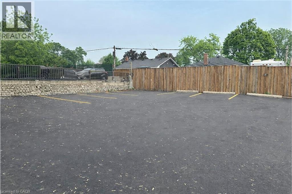 The property includes a paved parking area with marked parking spaces - 981 Mohawk Road E, Hamilton, ON - Outdoor