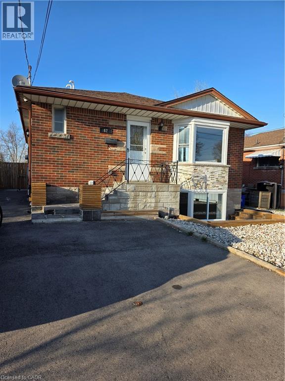 The property features a brick exterior with stone accents and a bay window - 62 Richwill Road Unit# Lower, Hamilton, ON - Outdoor