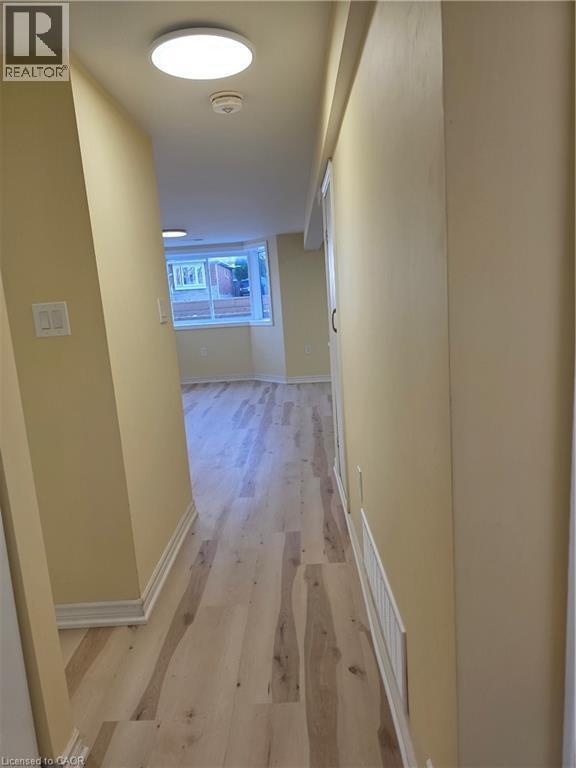A hallway with light-colored flooring, neutral walls, and a circular ceiling light fixture - 62 Richwill Road Unit# Lower, Hamilton, ON - Indoor Photo Showing Other Room