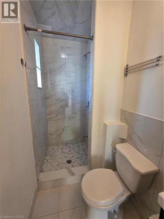 The bathroom features a walk-in shower with marble-patterned wall tiles and a mosaic-tiled floor - 62 Richwill Road Unit# Upper, Hamilton, ON - Indoor Photo Showing Bathroom