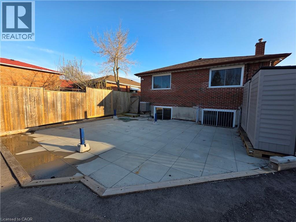 The property features a brick exterior with a brown shingled roof and a chimney - 62 Richwill Road Unit# Upper, Hamilton, ON - Outdoor With Exterior