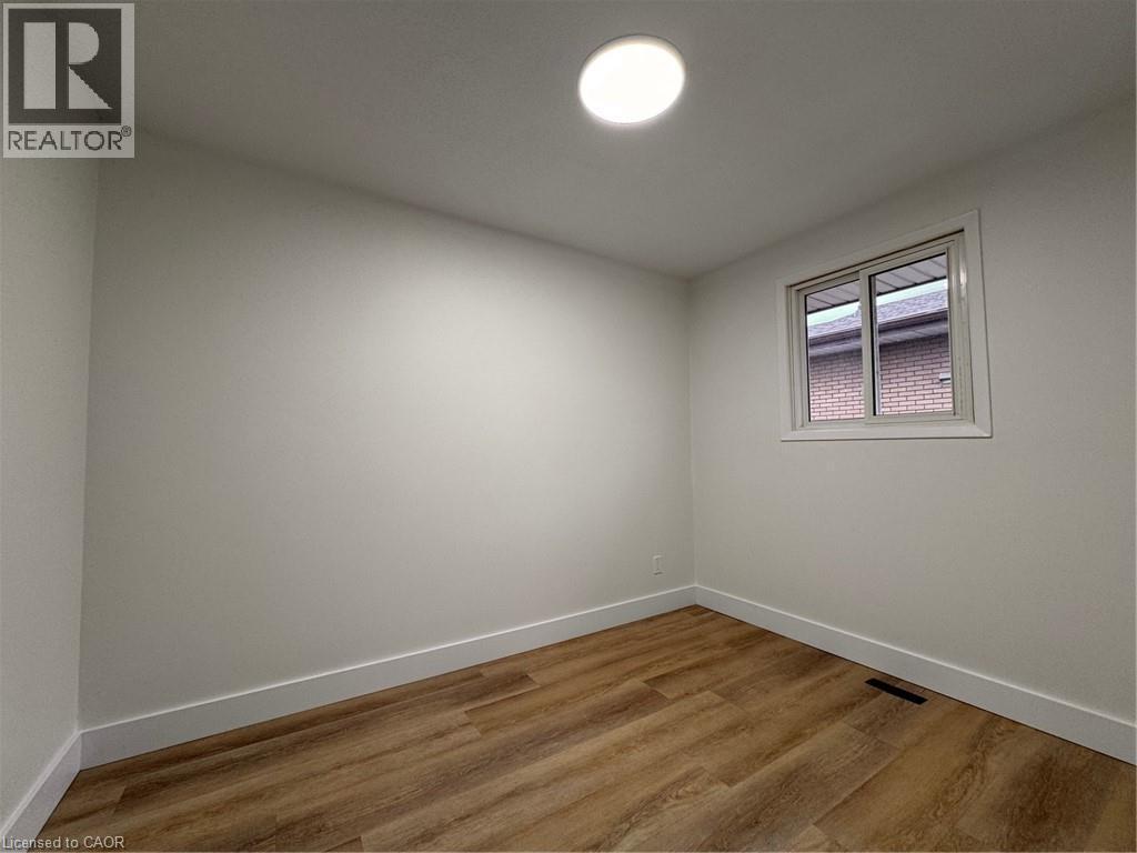 This room features light-toned walls, a window with white trim, and light wood-style flooring - 23 Arrowhead Crescent Unit# Upper, Kitchener, ON - Indoor Photo Showing Other Room