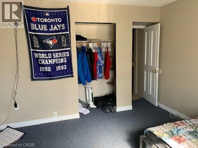 Bedroom with dark colored carpet and a closet - 65 Cardill Crescent Unit# A, Waterloo, ON - Indoor Photo Showing Bedroom