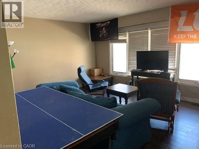 Living room with wood finished floors and a textured ceiling - 65 Cardill Crescent Unit# A, Waterloo, ON - Indoor