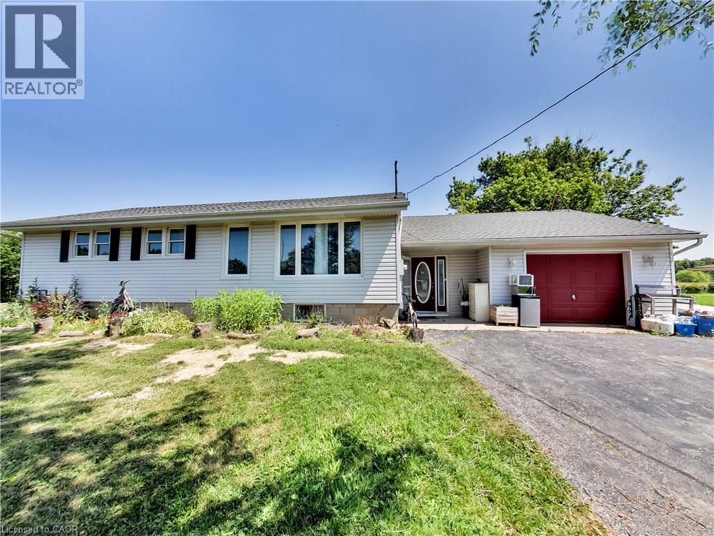 Ranch-style exterior with light-colored siding, contrasting black shutters, and a dark asphalt driveway - 9183 Silver Street, Caistor Centre, ON - Outdoor