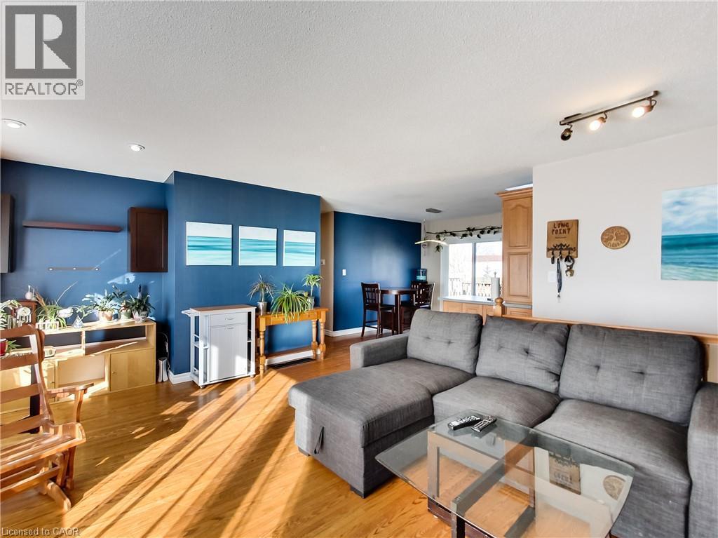 Open-concept living area with wood-finish flooring, recessed lighting, and a track light fixture - 9183 Silver Street, Caistor Centre, ON - Indoor Photo Showing Living Room