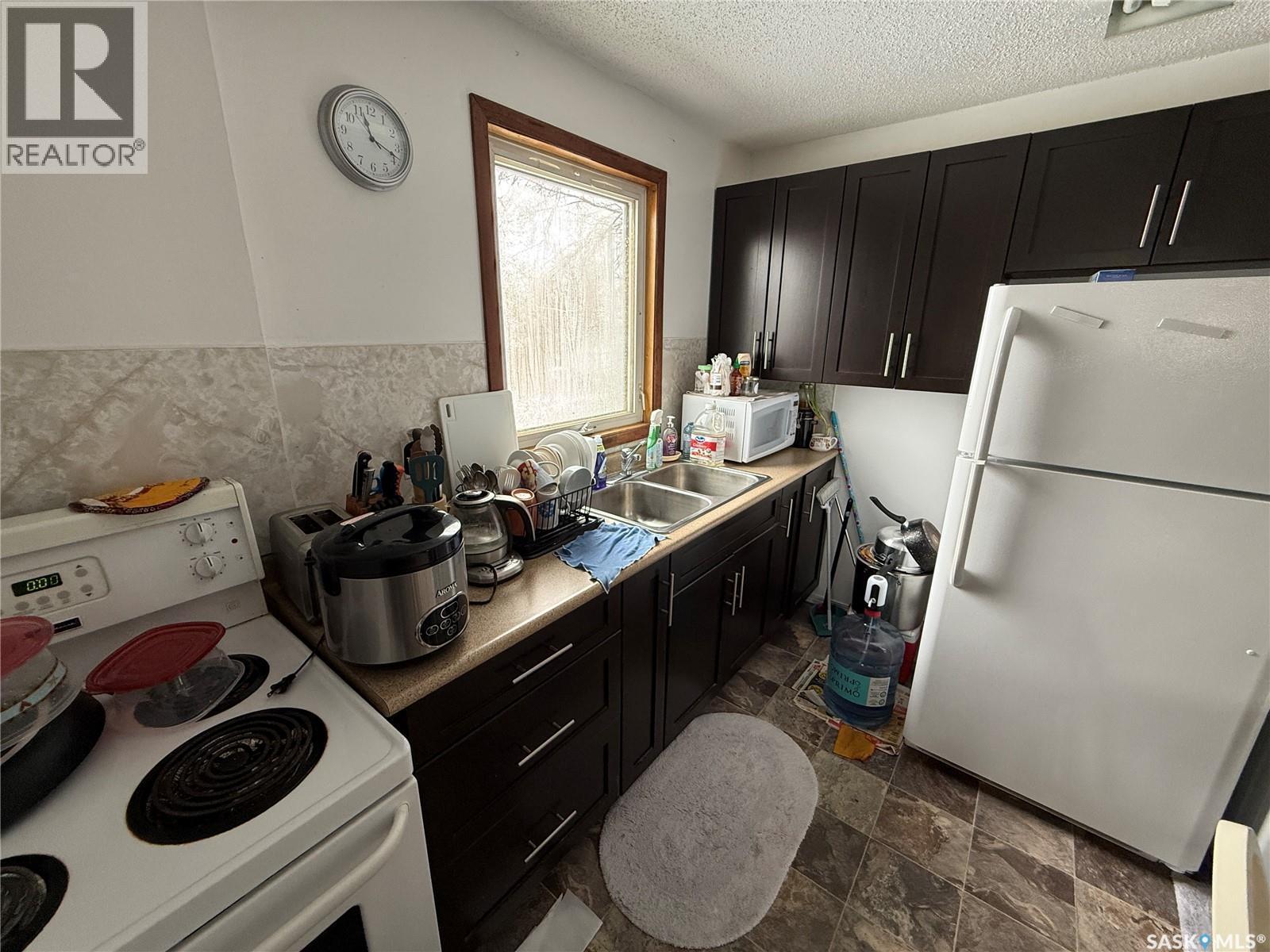 113 7Th Avenue Se, Weyburn, SK - Indoor Photo Showing Kitchen With Double Sink