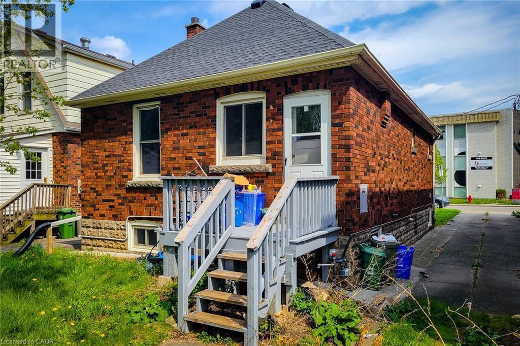 Brick exterior with a dark shingle roof and white soffit - 66 Cline Avenue Unit# Main Floor, Hamilton, ON - Outdoor