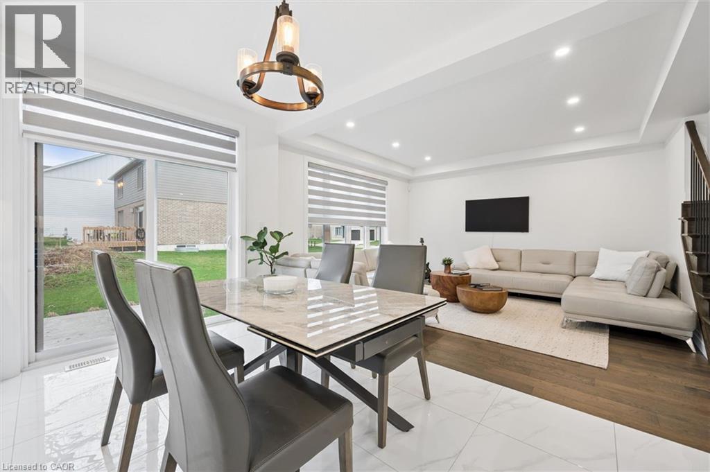 Open-concept living space with white tile flooring, wood-finish flooring, and recessed lighting - 213 Fallowfield Drive, Kitchener, ON - Indoor Photo Showing Dining Room