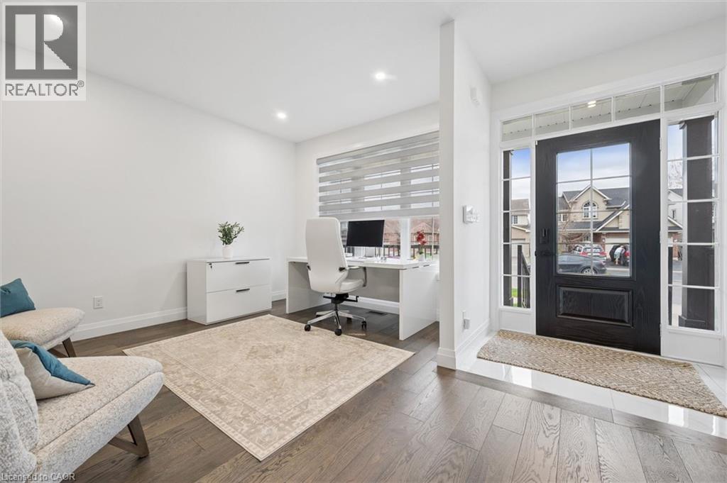 Entryway with dark wood-finish flooring featuring an opaque panel front door with sidelights and transom windows - 213 Fallowfield Drive, Kitchener, ON - Indoor Photo Showing Office
