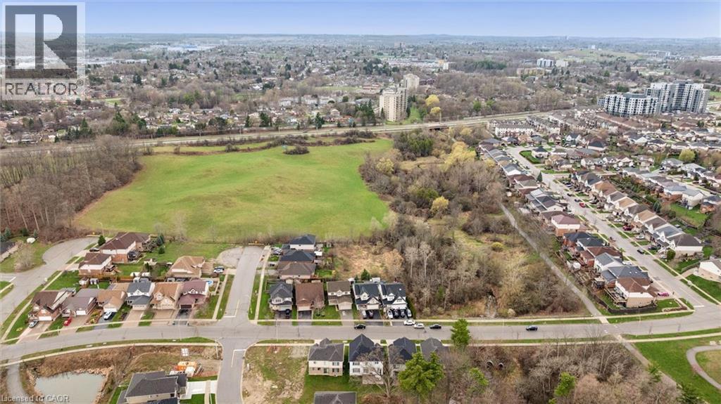 Aerial perspective showcasing an expansive green field bordered by residential streets with detached homes - 213 Fallowfield Drive, Kitchener, ON - Outdoor With View