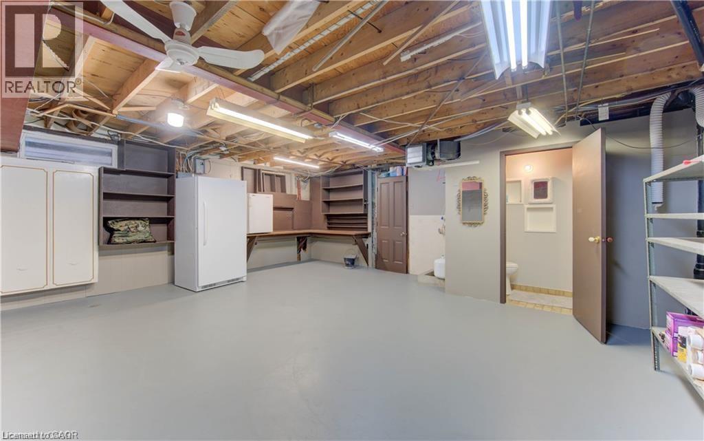 Finished basement with painted concrete flooring, exposed wood beam ceiling, and fluorescent lighting - 48 Dupont Street, Waterloo, ON - Indoor Photo Showing Basement
