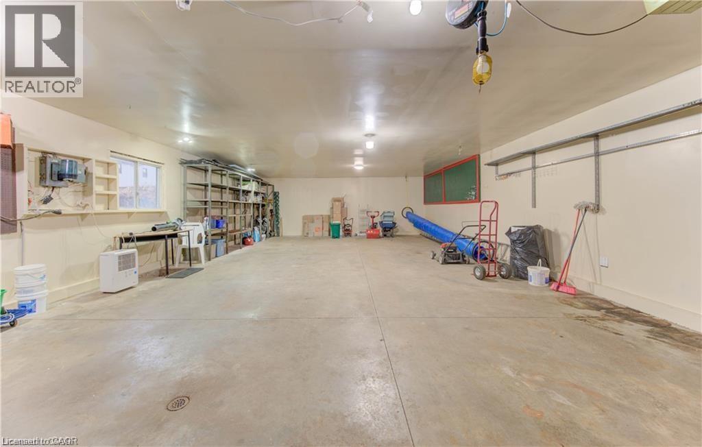 The property includes a spacious garage with a light-colored concrete floor and painted walls - 48 Dupont Street, Waterloo, ON - Indoor Photo Showing Other Room