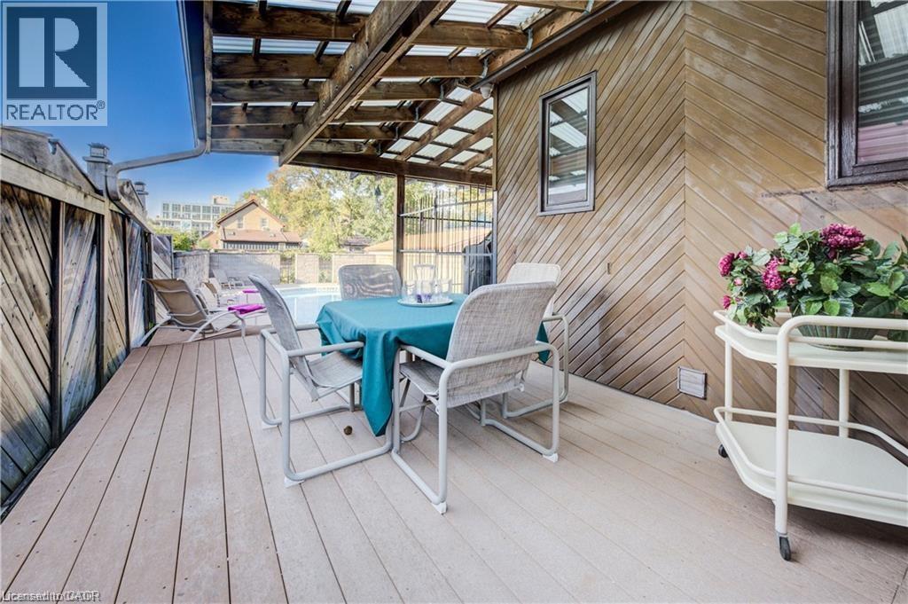 The property features a spacious outdoor deck area with a covered patio, providing a private space for relaxation - 48 Dupont Street, Waterloo, ON - Outdoor With Deck Patio Veranda With Exterior
