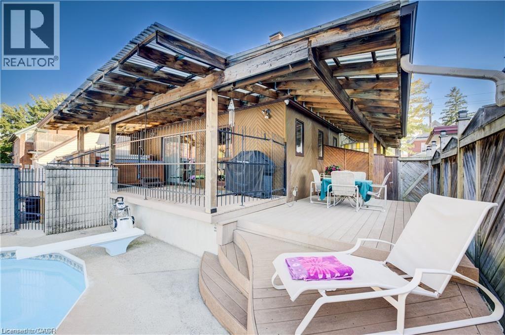 The property features a private outdoor area with a swimming pool, a diving board, and a wooden deck - 48 Dupont Street, Waterloo, ON -