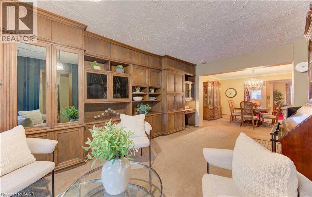 The living area features extensive built-in wooden cabinetry with mirrored panels and glass-fronted display shelves - 48 Dupont Street, Waterloo, ON - Indoor Photo Showing Living Room