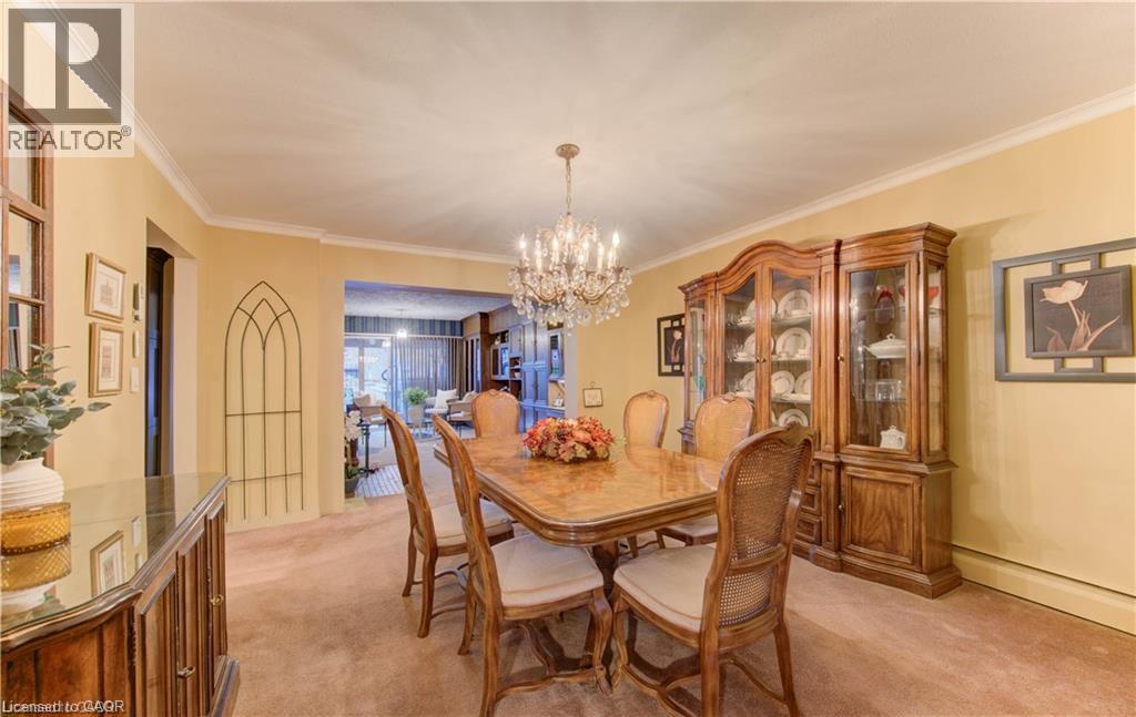 Dining area featuring a chandelier, crown molding, and carpeting - 48 Dupont Street, Waterloo, ON - Indoor Photo Showing Dining Room