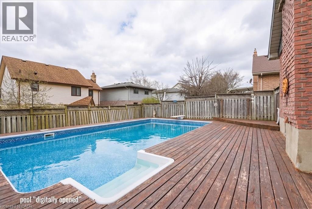 Outdoor swimming pool with a surrounding wooden deck and brick exterior - 110 Milton Avenue, Cambridge, ON - Outdoor With Above Ground Pool
