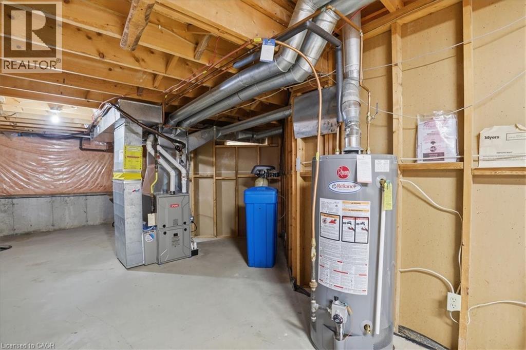 The utility area features exposed wooden beams, a water heater, a furnace, and a water softening system - 110 Milton Avenue, Cambridge, ON - Indoor Photo Showing Basement