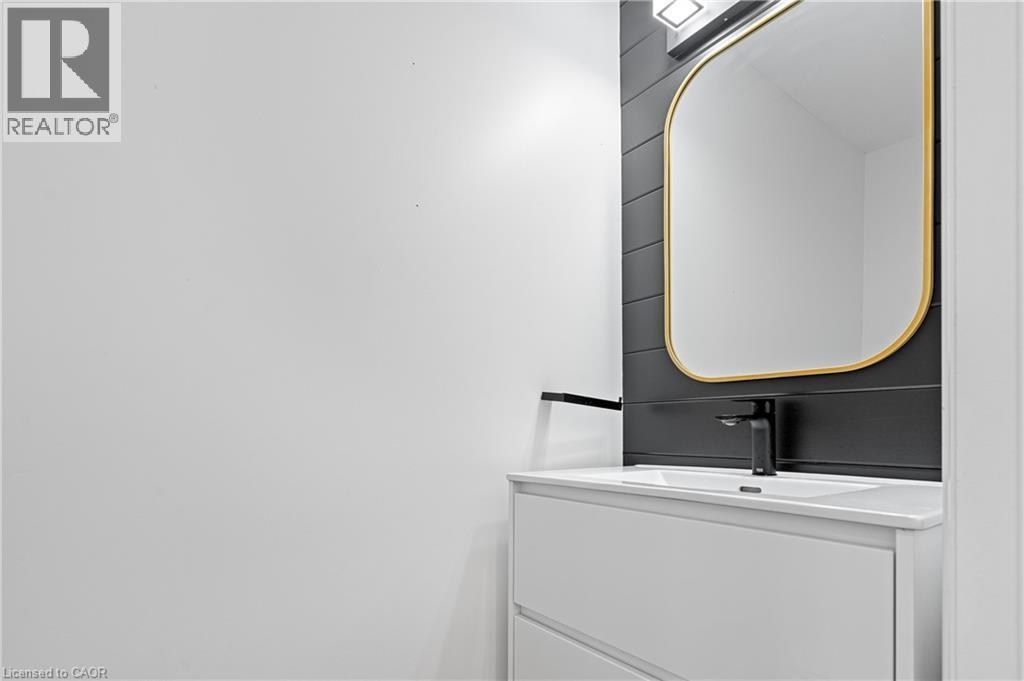 White floating vanity with integrated sink and matte black faucet - 1026 Wright Drive, Midland, ON - Indoor Photo Showing Laundry Room