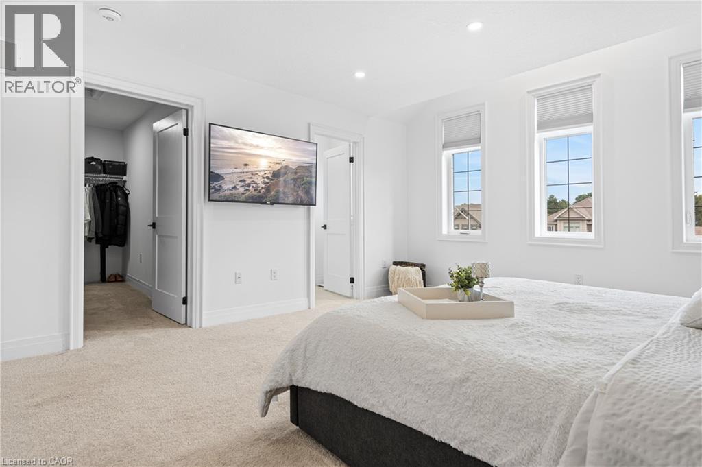 Carpeted bedroom with three windows featuring horizontal blinds - 1026 Wright Drive, Midland, ON - Indoor Photo Showing Bedroom