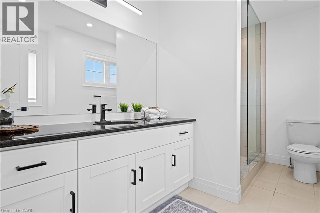 Double vanity with white cabinetry, black hardware, and dark countertop - 1026 Wright Drive, Midland, ON - Indoor Photo Showing Bathroom
