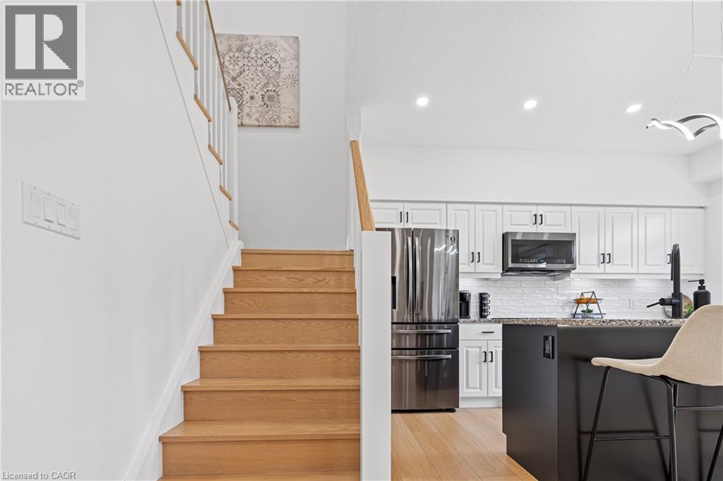 Natural wood-finish staircase with white risers and railing, complementing the light wood-finish flooring - 1026 Wright Drive, Midland, ON - Indoor Photo Showing Kitchen With Upgraded Kitchen