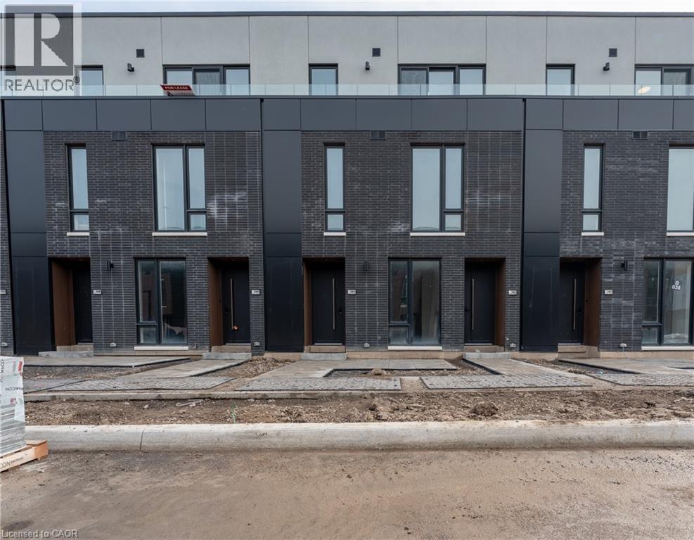 The property features a contemporary facade with dark brick and large windows - 144 Everett Common, St. Catharines, ON - Outdoor