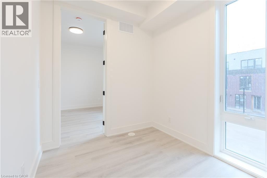 This space features light-toned flooring, white walls, and a window providing natural light - 144 Everett Common, St. Catharines, ON - Indoor Photo Showing Other Room