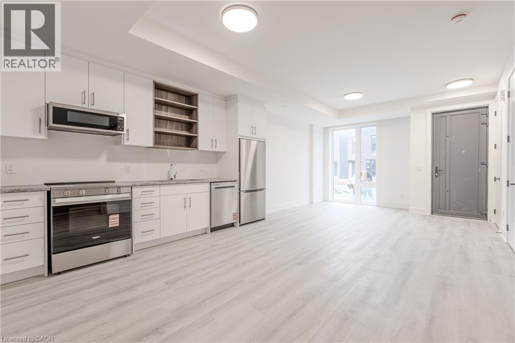 Open concept living area with light-toned flooring and white walls - 144 Everett Common, St. Catharines, ON - Indoor Photo Showing Kitchen